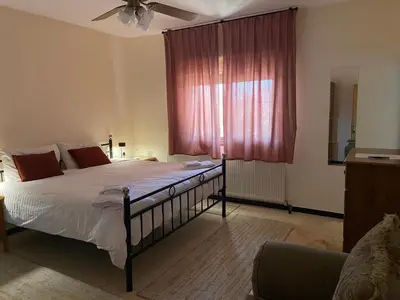 a bedroom with a large bed with a red window at Baytna Hotel in Petra