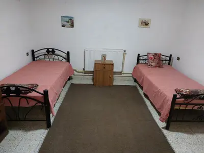 a room with two beds and a wooden dresser at Casa la Serena in Madaba