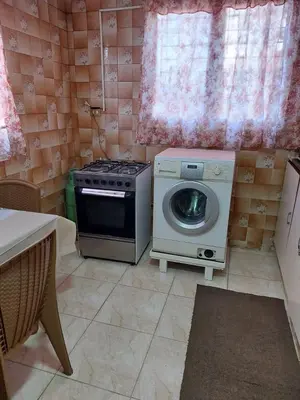 a kitchen with a stove and a washing machine at Casa la Serena in Madaba