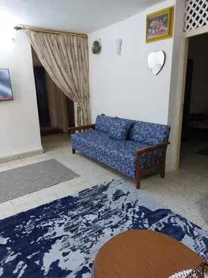 a living room with a blue couch and a rug at Casa la Serena in Madaba