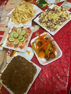 a table topped with plates of food and french fries at المنشيه ان in Al Manshīyah