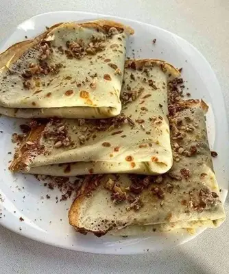 a white plate with four pieces of food on it at المنشيه ان in Al Manshīyah