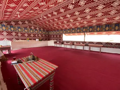 a large room with a table and benches in it at Wadi Rum 5-hour tour with sunset or morning, overnight stay with two meals and a Bedouin tent with a private bathroom Prices are for two people in Wadi Rum