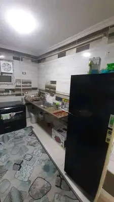 a kitchen with a counter and a refrigerator at دبه حانوت هاوس in Raʼs an Naqb