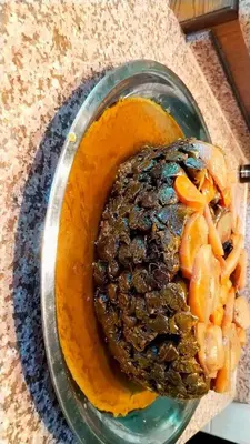 a plate of food on a counter with orange sauce at دبه حانوت هاوس in Raʼs an Naqb