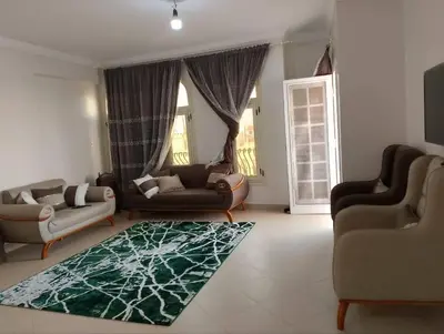 a living room with two couches and a green rug at Cool apartment in Maḩaţţat al Jufūr