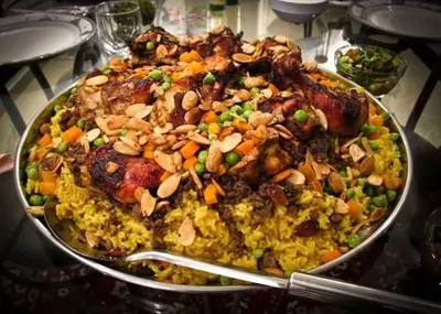 a pan of food with meat and vegetables on a table at Cool apartment in Maḩaţţat al Jufūr
