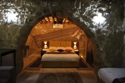 a bedroom with a bed in a stone wall at Hartna zaman in Taiyiba