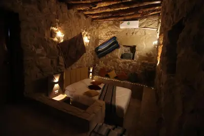a bedroom with two beds in a stone room at Hartna zaman in Taiyiba