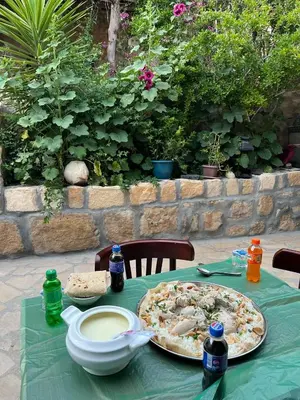 a table with a pizza on a green table cloth at Hartna zaman in Taiyiba