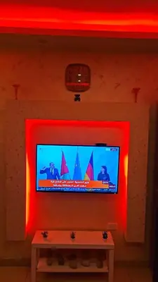 a flat screen tv with red lights on a wall at Al Tamimi Furnished Apartments in Amman