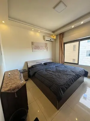 a bedroom with a large bed and a window at Al Tamimi Furnished Apartments in Amman