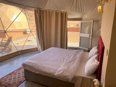 a bedroom with a bed in a tent at Al Jawhara Luxury Camp in Wadi Rum