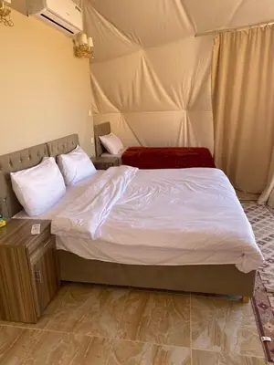 a bedroom with a bed in a tent at Al Jawhara Luxury Camp in Wadi Rum