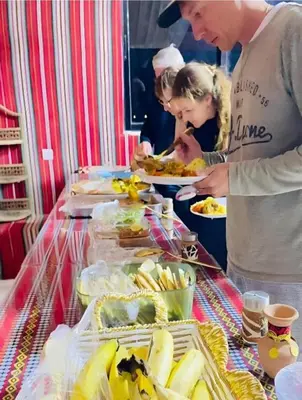 a group of people standing around a buffet with food at Aethera Sky Retreat Wadi Rum in Wadi Rum