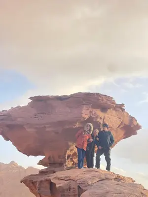 a group of people standing on top of a rock at Aethera Sky Retreat Wadi Rum in Wadi Rum
