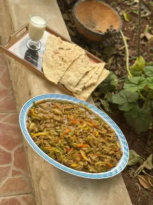 a bowl of food on a table next to a tray at sliver apartment in Bayt Raʼs