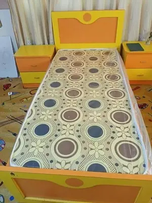 a bed with a wooden frame in a room at sliver apartment in Bayt Raʼs