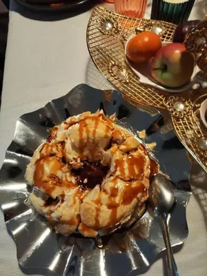a plate of donuts and apples on a table at sliver apartment in Bayt Raʼs