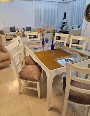 a white dining room table and chairs with wine glasses at sliver apartment in Bayt Raʼs