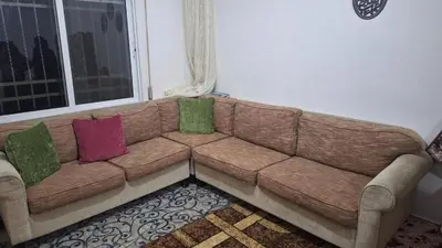 a brown couch with three colorful pillows on it at rafat house in Amman