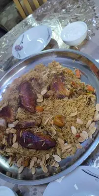 a plate of rice and mushrooms on a table at rafat house in Amman