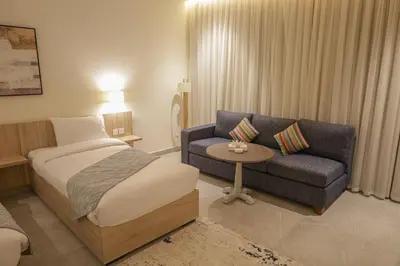 a hotel room with a bed and a couch at ISHQ Hotel in Aqaba