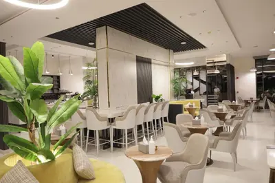 a restaurant with white chairs and tables and plants at ISHQ Hotel in Aqaba