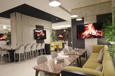 a restaurant with tables and a fire on the wall at ISHQ Hotel in Aqaba