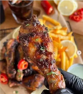 a plate of food with a piece of meat and fries at too house in Al Mughayyir