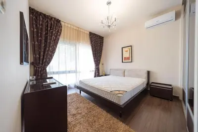 a bedroom with a bed and a window at Tower Apartment in Amman