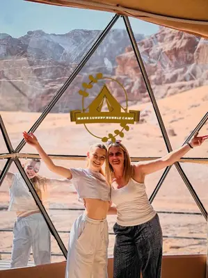 a group of people standing in a tent in the desert at RUM MARS BUBBLE lUXURY CAMP in Wadi Rum