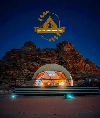 a large dome building with a sign above a bench at RUM MARS BUBBLE lUXURY CAMP in Wadi Rum