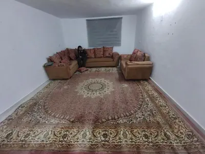 a living room with a couch and a rug at شقة مفروشة في عجلون رأس منيف in Ajloun