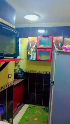 a kitchen with a microwave and a refrigerator at الخريطه هاوس in Tall al Misţāḩ