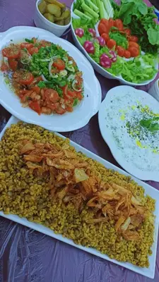 a table topped with plates of food and vegetables at الخريطه هاوس in Tall al Misţāḩ