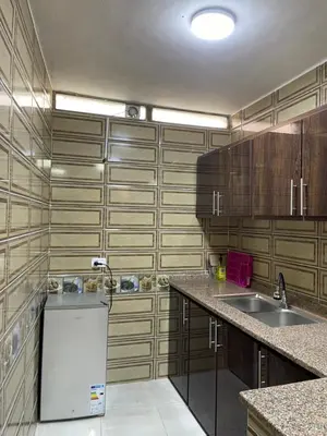 a kitchen with wooden cabinets and a white refrigerator at Petra 555 Rooms & Apartment in Wadi Musa