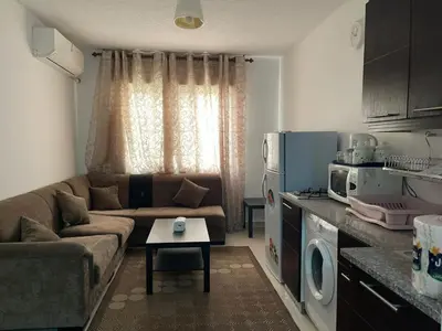 a small living room with a couch and a kitchen at الشاعر للشقق المفروشة in Amman