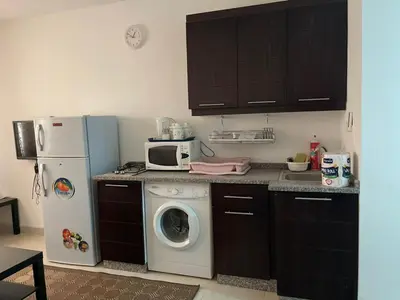 a kitchen with a washing machine and a refrigerator at الشاعر للشقق المفروشة in Amman