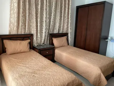 two beds sitting next to each other in a bedroom at الشاعر للشقق المفروشة in Amman