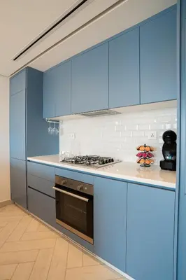 a kitchen with blue cabinets and a stove at Ayla B12 Beach Apartment Aqaba in Aqaba