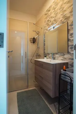 a bathroom with a sink and a shower with a mirror at Ayla B12 Beach Apartment Aqaba in Aqaba