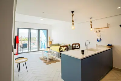 a kitchen with a sink and a living room at Ayla B12 Beach Apartment Aqaba in Aqaba