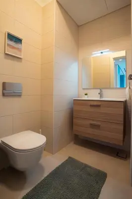 a bathroom with a toilet and a sink and a mirror at Ayla B12 Beach Apartment Aqaba in Aqaba