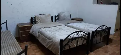 a bedroom with two beds and a dresser at بيت الحجر in Amman