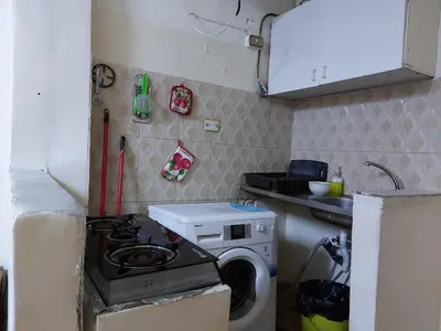 a small kitchen with a stove and a washing machine at بيت الحجر in Amman