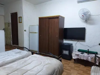 a room with two beds and a flat screen tv at بيت الحجر in Amman