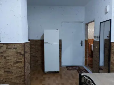 a white refrigerator in a room with a door at بيت الحجر in Amman