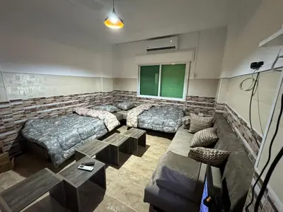 a bedroom with two beds and a couch at Decapolis 8 in Irbid