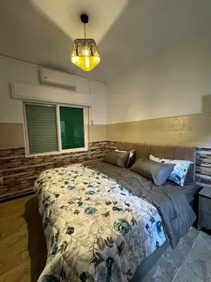 a bedroom with a large bed and a chandelier at Decapolis 8 in Irbid